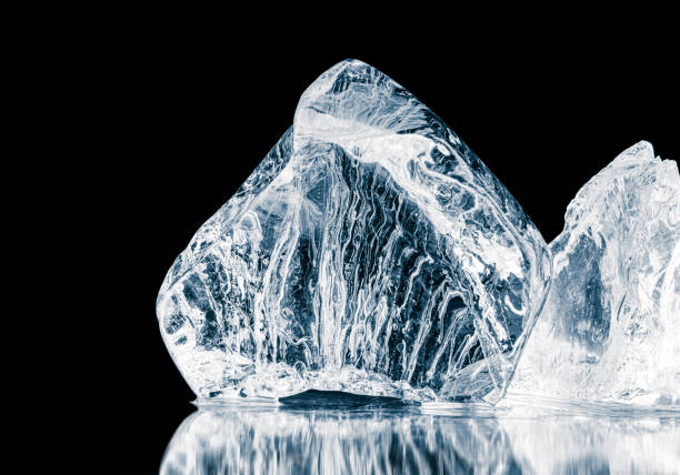 istock Natural textured with air bubbles pieces of ice, on a black reflective surface. 1477846641
