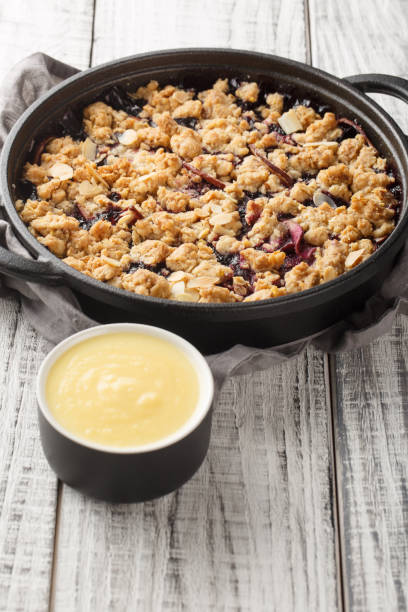 istock Swedish pie Smulpaj baked with apples and blueberries close-up in a pan. Vertical 1477846685