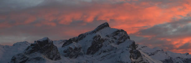 nuvole luminose illuminate sulle montagne innevate in svizzera. - bernese oberland gstaad winter snow foto e immagini stock