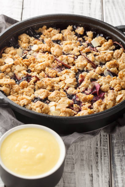 istock Swedish Fruit Crumble Pie Smulpaj with home made vanilla sauce closeup. Vertical 1477847058
