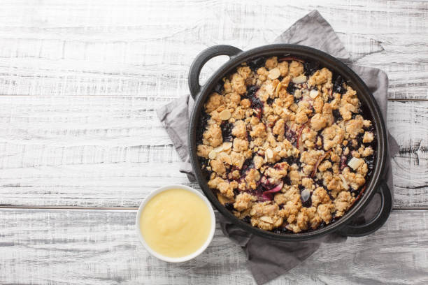 istock Smulpaj summer berry fruit pie baked with apples and blueberries served with vanilla sauce close-up in a pan. Horizontal top view 1477847151