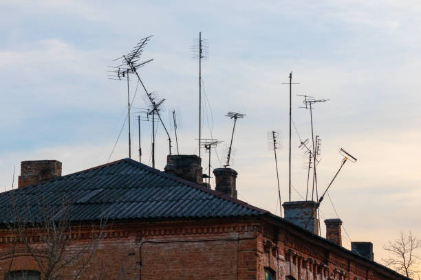 many old television antennas on the roof of an old house - television aerial roof antenna city imagens e fotografias de stock