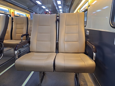 Interior of an empty passenger car commuter train with blue seats.