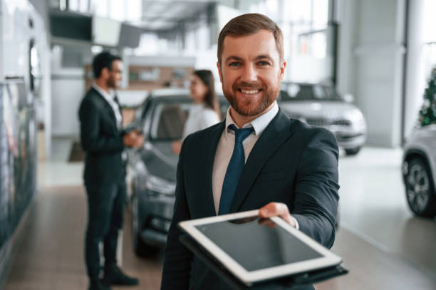 istock Using graphic tablet. Three people are working together in the car showroom 1477849423
