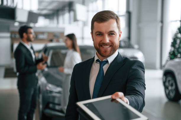 istock Using graphic tablet. Three people are working together in the car showroom 1477849428