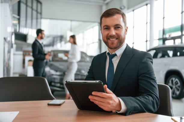 istock Using graphic tablet. Three people are working together in the car showroom 1477849442