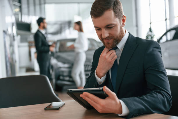 istock Using graphic tablet. Three people are working together in the car showroom 1477849458