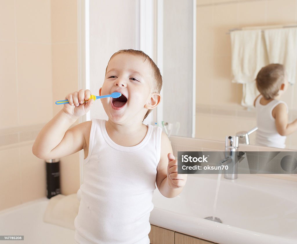 Chłopiec czyszczenia zębów w łazience - Zbiór zdjęć royalty-free (Chłopcy)