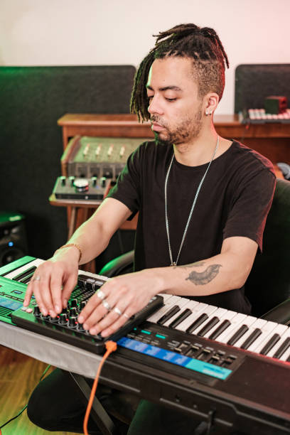 istock Male mixed race Musician practising at home recording studio 1477854009