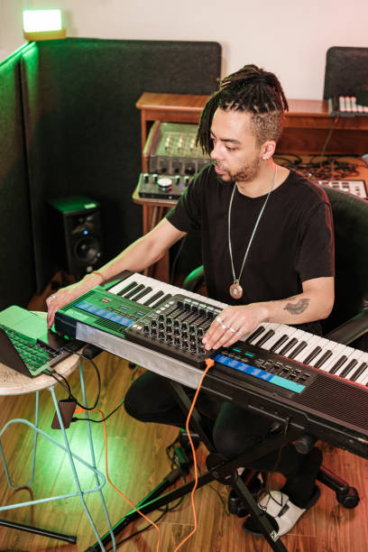 istock Male mixed race Musician practising at home recording studio 1477854010