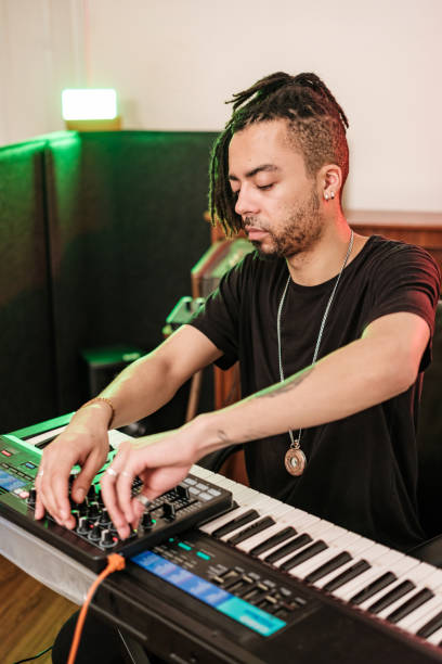 istock Male mixed race Musician practising at home recording studio 1477854132