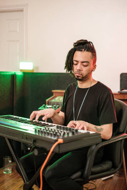 istock Male mixed race Musician practising at home recording studio 1477854270