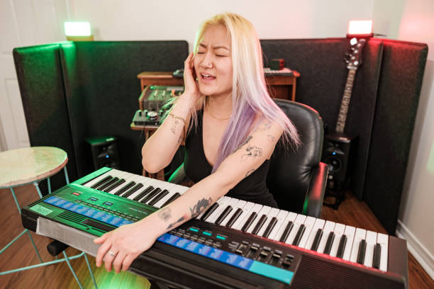 корейская музыкантка, тренирующаяся в домашней студии звукозаписи - электропиано стоковые фото и изображения