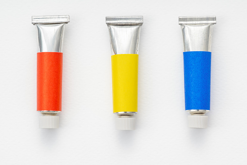 Three of the primary colour tube on rough white paper