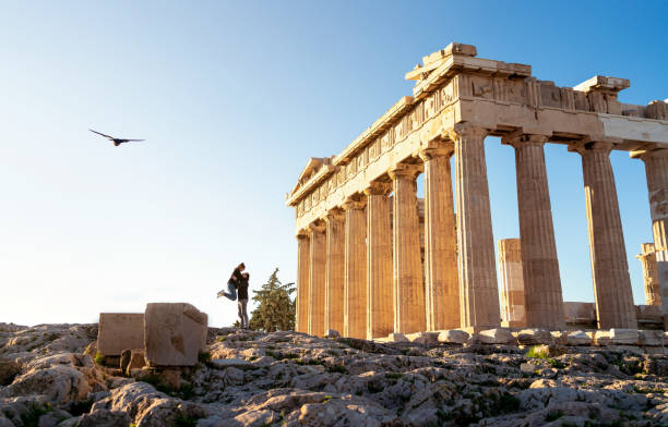 Greece, Athens. Tourist couple at Acropolis. Two people at Parthenon ruins. Travel and tourism. Woman and man on romantic date, city vacation or honeymoon. stock photo