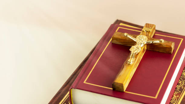istock Crucifix with Christian bibles on a light gradient background with divine light 1477860396