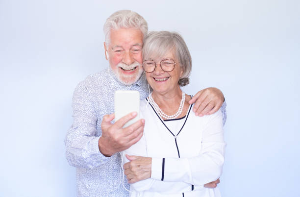 istock Video call concept. Happy senior couple laughing using smartphone together for video chat online communication, man and woman expressing happiness and positive emotions 1477862691