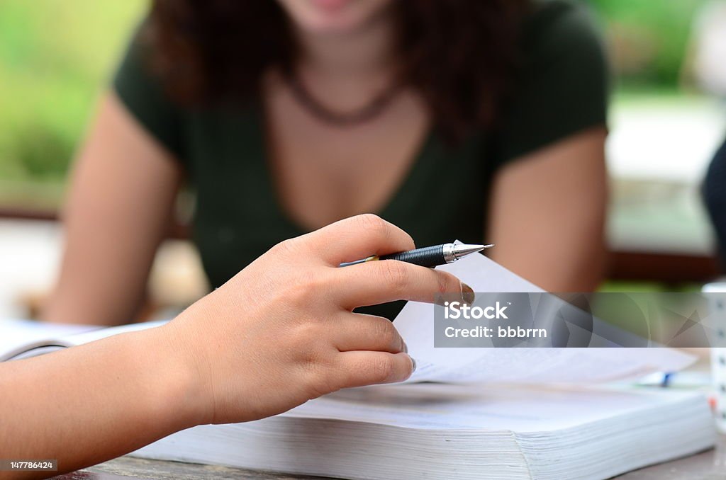 hand turning page hand holding a pen Horizontal Stock Photo