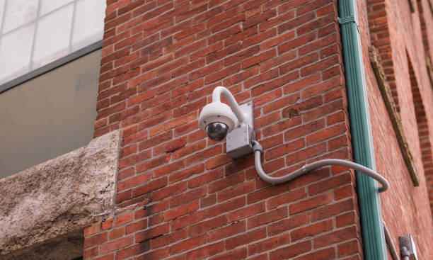 istock Security camera mounted on a building overlooking a busy street, while roadside camera on a pole captures passing vehicles on the highway 1477868084