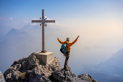 Hiker on top of mountain with open arms raised