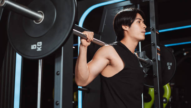 istock Man working out Bodybuilder with barbell weights at the gym. bodybuilder doing exercises with barbell. training sport healthy lifestyle bodybuilding, Athlete builder muscles lifestyle. 1477871363