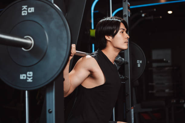 istock Man working out Bodybuilder with barbell weights at the gym. bodybuilder doing exercises with barbell. training sport healthy lifestyle bodybuilding, Athlete builder muscles lifestyle. 1477871455