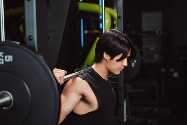istock Man working out Bodybuilder with barbell weights at the gym. bodybuilder doing exercises with barbell. training sport healthy lifestyle bodybuilding, Athlete builder muscles lifestyle. 1477871492