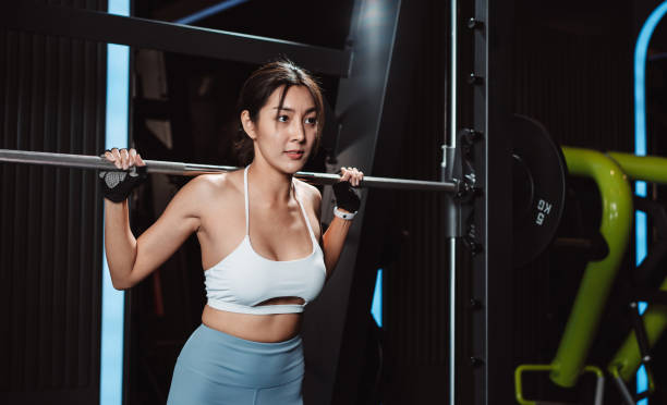 istock Woman working out Bodybuilder with barbell weights at the gym. bodybuilder doing exercises with barbell. training sport healthy lifestyle bodybuilding, Athlete builder muscles lifestyle. 1477871755