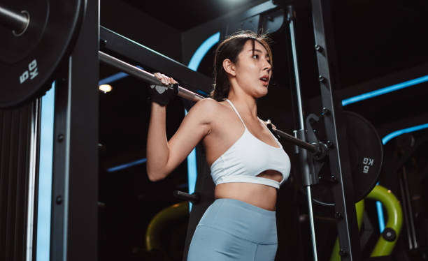 istock Woman working out Bodybuilder with barbell weights at the gym. bodybuilder doing exercises with barbell. training sport healthy lifestyle bodybuilding, Athlete builder muscles lifestyle. 1477871816