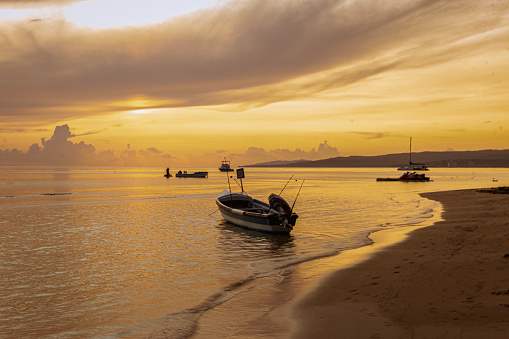 Fishing boats near to and on the seashore as fishers set out during a dramatic sunrise in Ochos Rios, Jamaica in September.