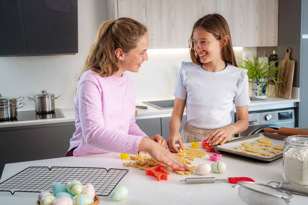 istock Two happy girls having fun making Easter cookies at home 1477873522