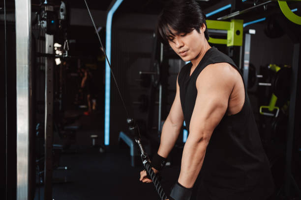 istock Man working out with weights training machine exercise lifting dumbbells at fitness gym. Fitness muscular body weight loss. Bodybuilding healthy lifestyle. 1477873570