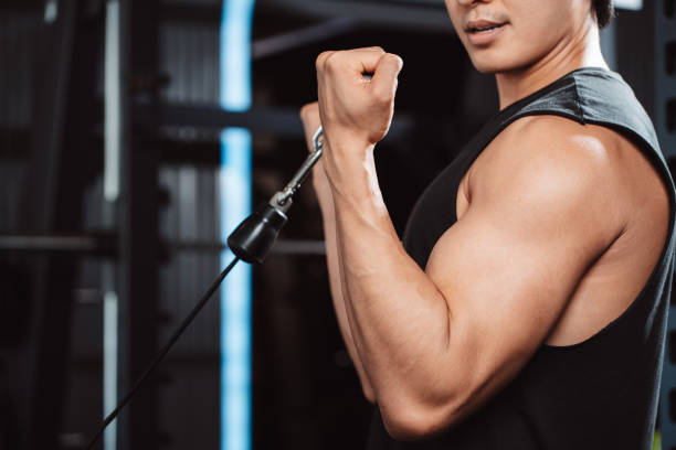 istock Man working out with weights training machine exercise lifting dumbbells at fitness gym. Fitness muscular body weight loss. Bodybuilding healthy lifestyle. 1477873587