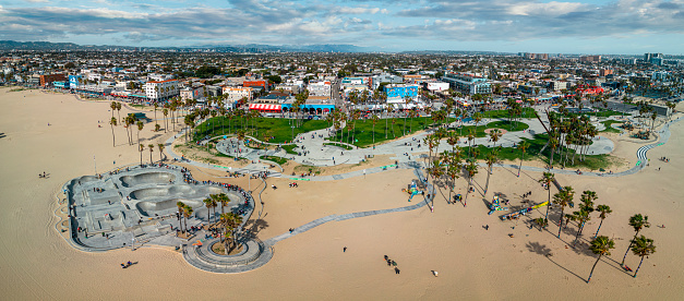 The Venice Beach skate park is on the sand next to the boardwalk with restaurants and entertaining performers.