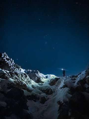 hiker on the night mountain with starry sky