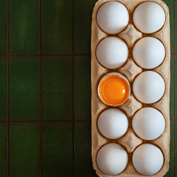 frische rohe eier vom bauernhof in pappschale auf grünem hintergrund. das hauptsymbol der feier von ostern. - breakfast easter yellow easter egg stock-fotos und bilder