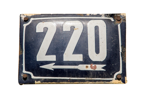 Weathered grunge square metal enameled plate of number of street address with number 220 isolated on white background