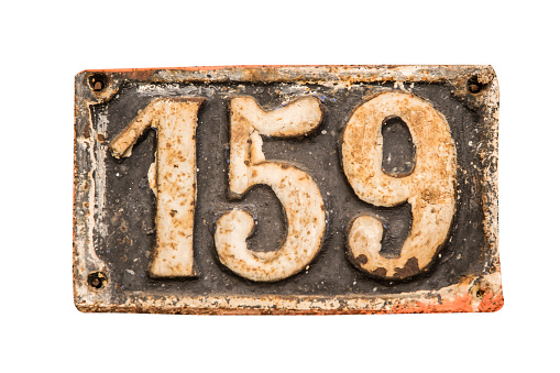 Old retro weathered cast iron plate with number 159 closeup isolated on white background