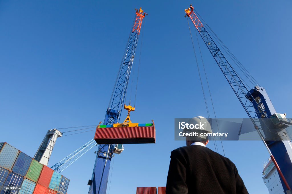 Shipping of containers Lifting a container from stack to a ship. Customs Official Stock Photo