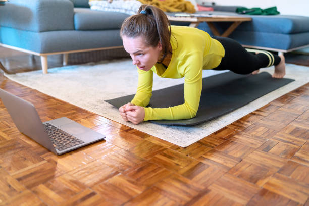 istock Female endurance and motivation, woman doing plank exercise at home. 1477883271
