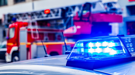 Luz de flash azul del coche de policía contra el camión de bomberos rojo photo