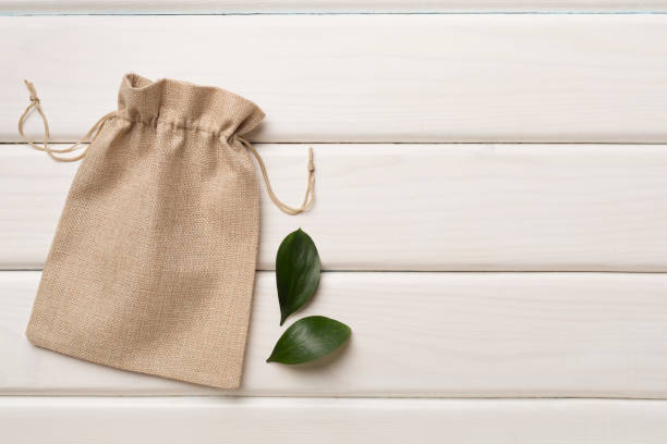 istock Small eco sack on wooden background. Top view. 1477884703