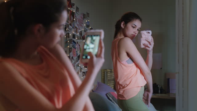 happy teenage girl taking selfie photo using smartphone posing in mirror sharing stylish fashion on social media enjoying weekend at home teen self image