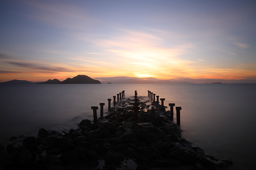 old, rusty abandoned and dismantled pier. sky space is empty. suitable for writing. Seaside town of Turgutreis and spectacular sunshine. Long Exposure shoot. tranquility scene.
