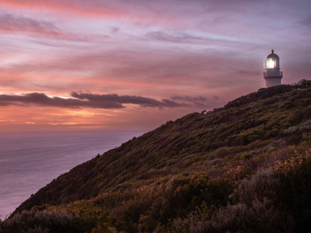 istock Rocky coastline and lighthouse at sunset 1477899932