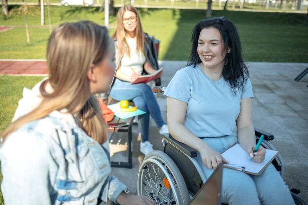 istock College student with disability spending time with friends outside and learning 1477900803