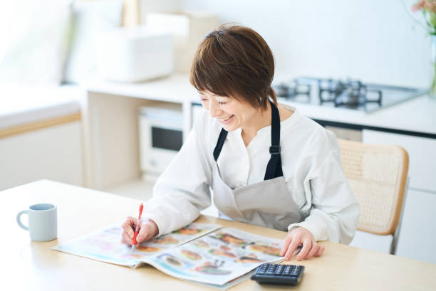 istock Woman looking at grocery advertisement 1477901164