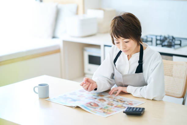 istock Woman looking at grocery advertisement 1477901214