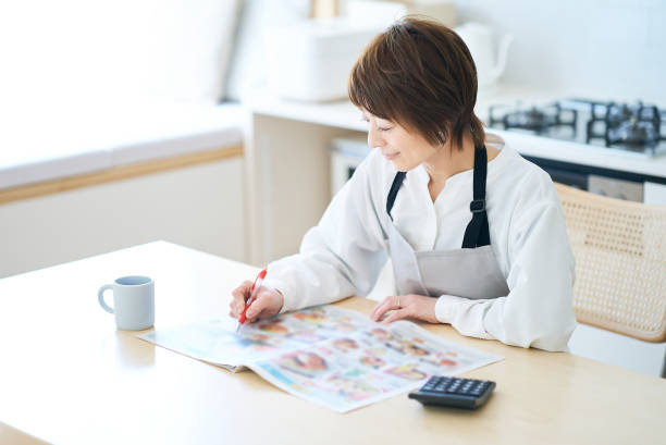 istock Woman looking at grocery advertisement 1477901275