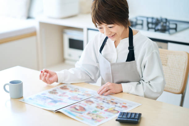 istock Woman looking at grocery advertisement 1477901402